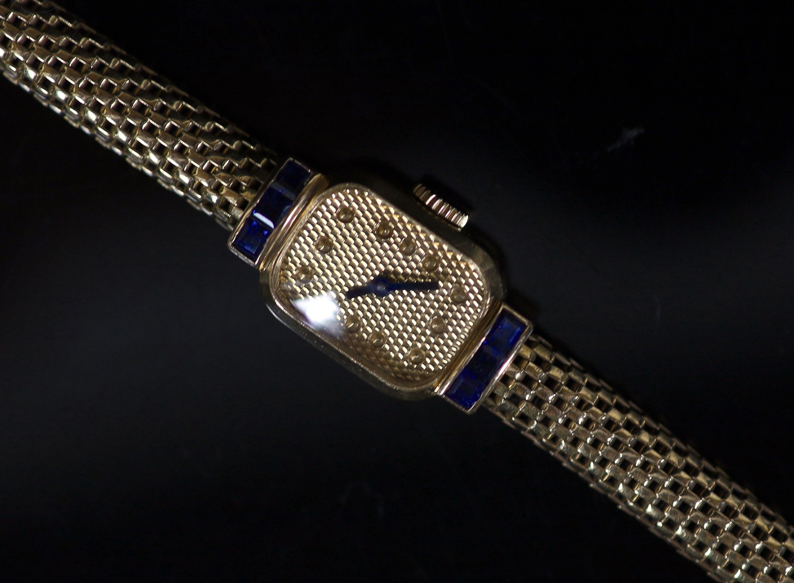 A lady's mid 20th century French Boucheron 18ct gold and six stone sapphire set manual wind cocktail watch, on an integral 18ct gold 'cage link' bracelet